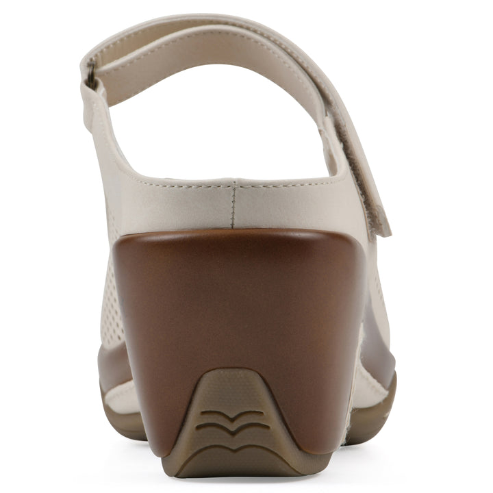 Rear view of a egg shell colored clog with a closed toe and adjustable strap, featuring a perforated diamond design and a low heel.