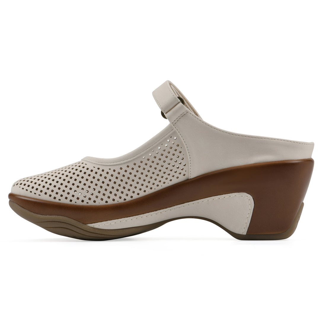 Side view of a egg shell colored clog with a closed toe and adjustable strap, featuring a perforated diamond design and a low heel.