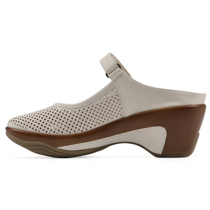 Side view of a egg shell colored clog with a closed toe and adjustable strap, featuring a perforated diamond design and a low heel.