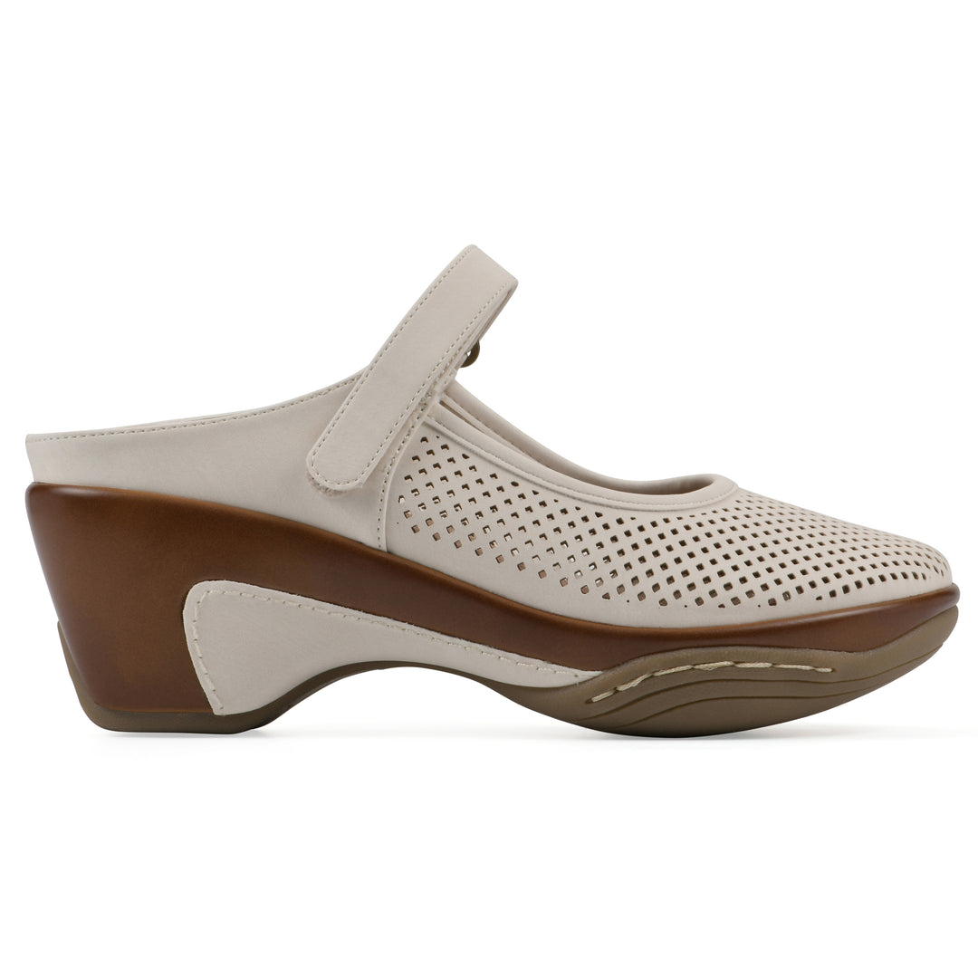 Side view of a egg shell colored clog with a closed toe and adjustable strap, featuring a perforated diamond design and a low heel.
