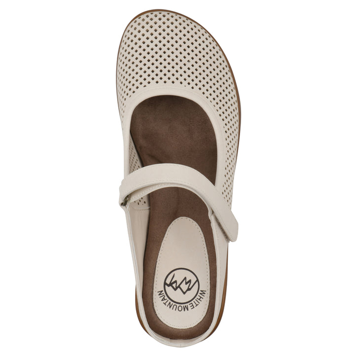 Top view of a egg shell colored clog with a closed toe and adjustable strap, featuring a perforated diamond design and a low heel.