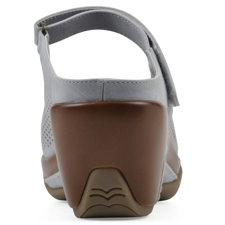Rear view of a pastel blue colored clog with a closed toe and adjustable strap, featuring a perforated diamond design and a low heel.