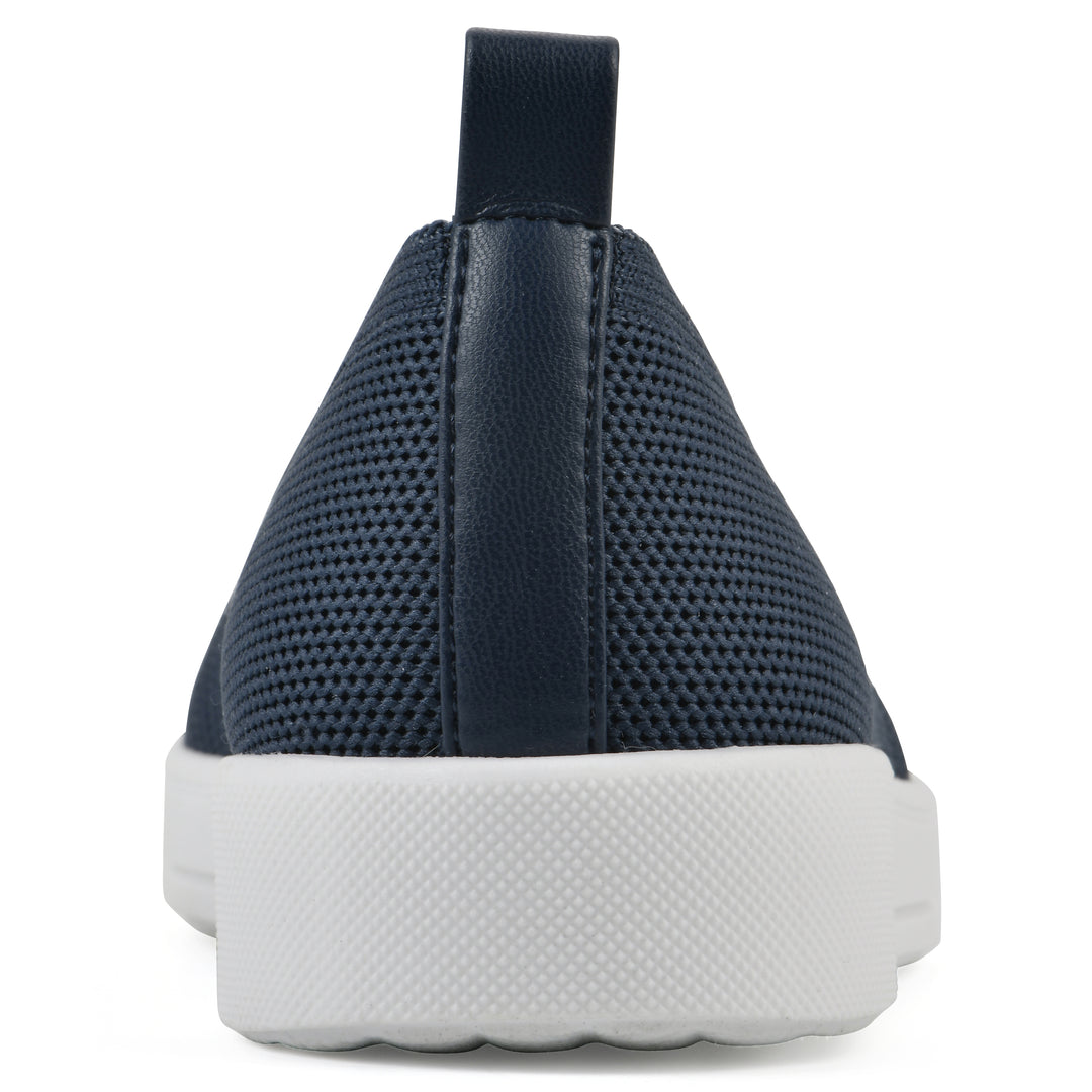 Heel view of a navy slip-on sneaker with white sole, and perforated mesh fabric