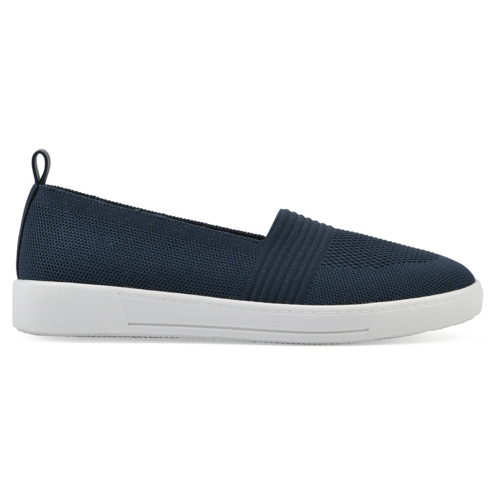 Side view of a navy slip-on sneaker with white sole, and perforated mesh fabric