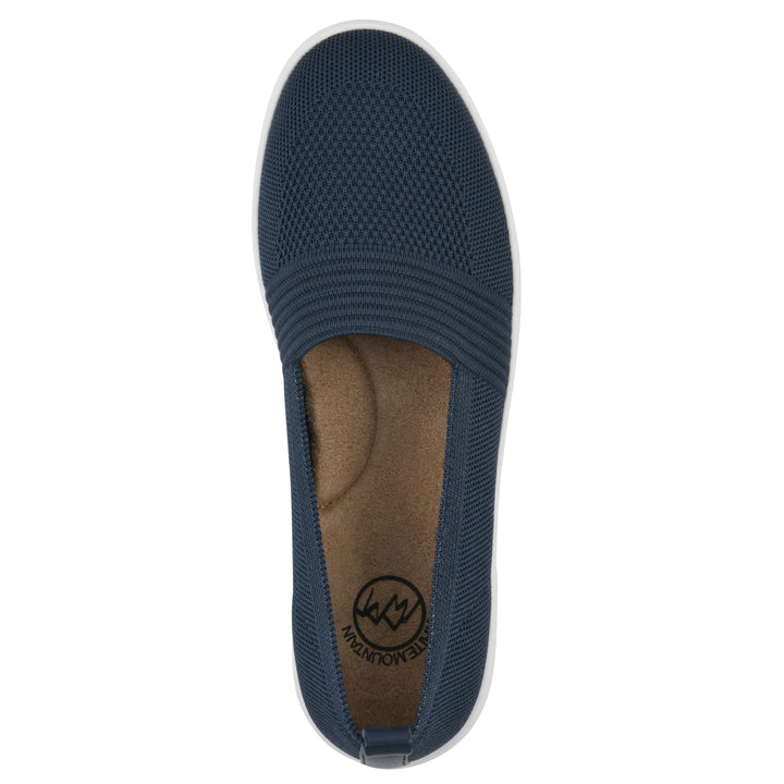 Top view of a navy slip-on sneaker with white sole, and perforated mesh fabric