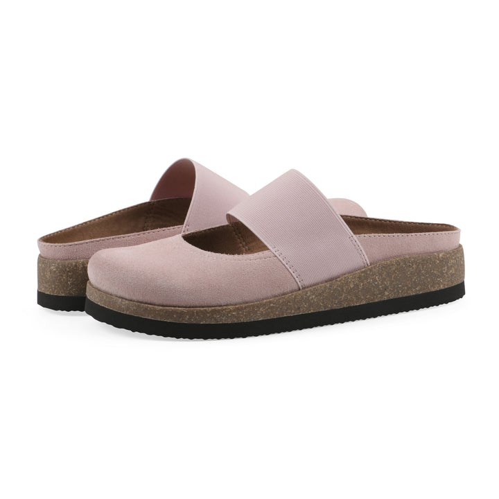 Angle view of a pair of light pink suede backless clogs with Mary Jane style center strap and a brown sole with black bottom