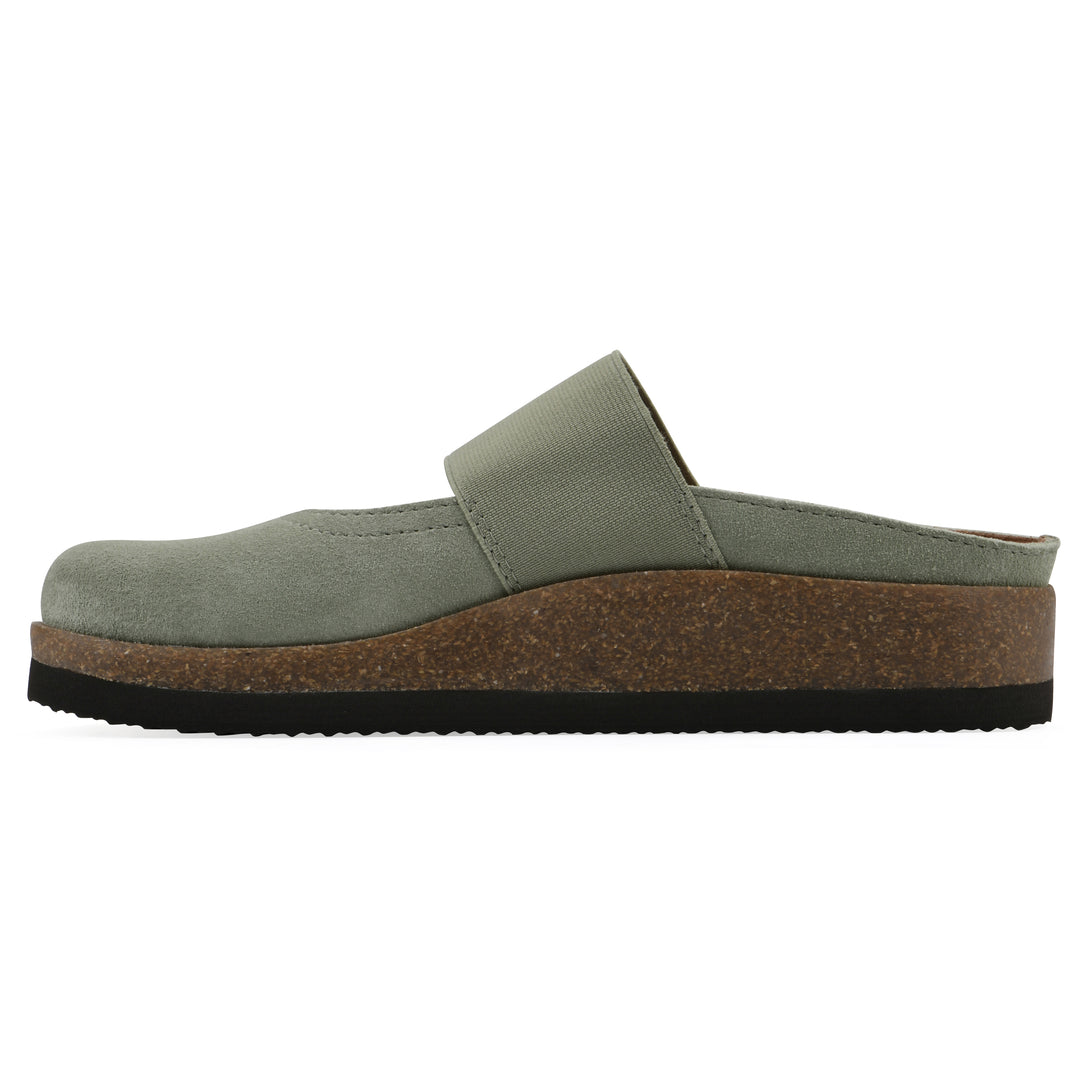 Side view of a sage suede backless clog with Mary Jane style center strap and a brown sole with black bottom