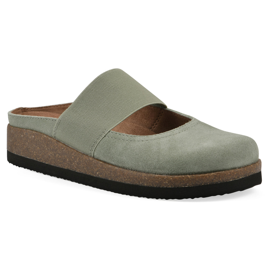Angle view of a sage suede backless clog with Mary Jane style center strap and a brown sole with black bottom