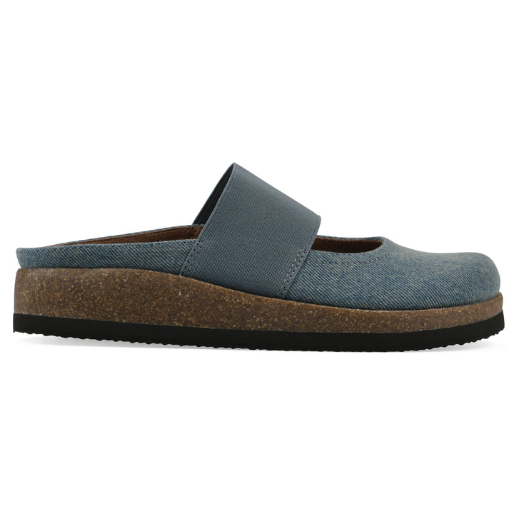 Side view of a denim backless clog with Mary Jane style center strap and a brown sole with black bottom