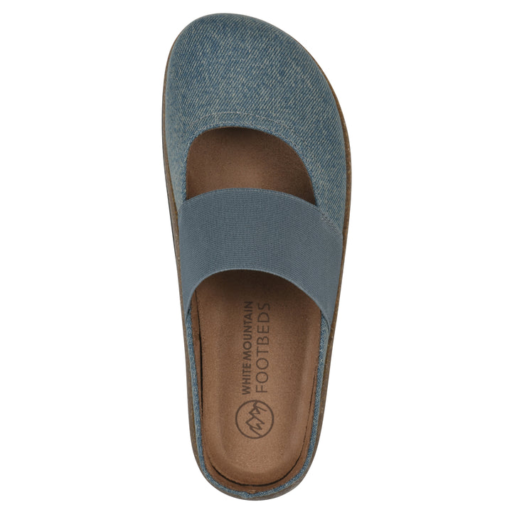 Top view of a denim backless clog with Mary Jane style center strap and a brown sole with black bottom