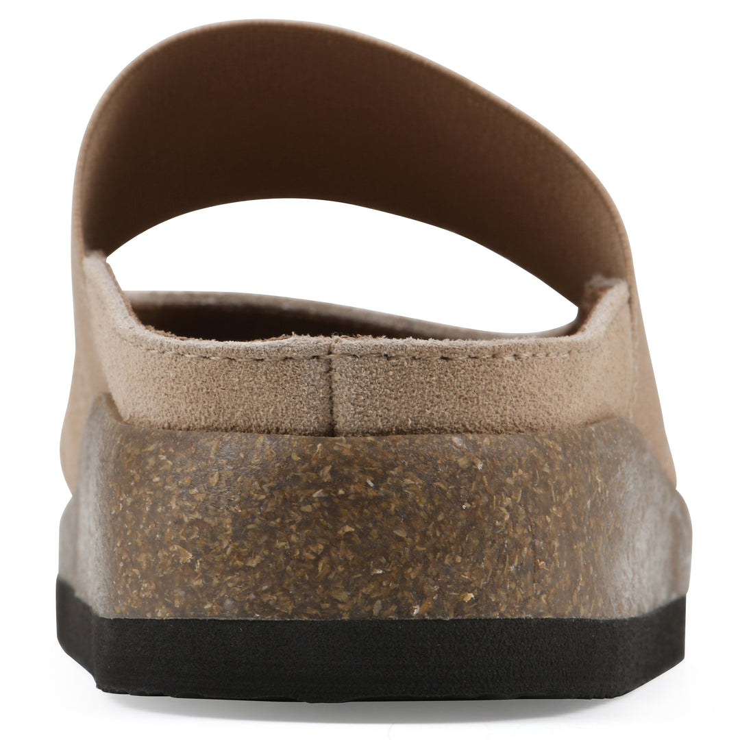 Rear view of a beach wood suede backless clog with Mary Jane style center strap and a brown sole with black bottom