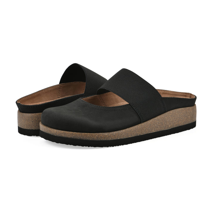 Angle view of a pair of black leather backless clogs with Mary Jane style center strap and a brown sole with black bottom