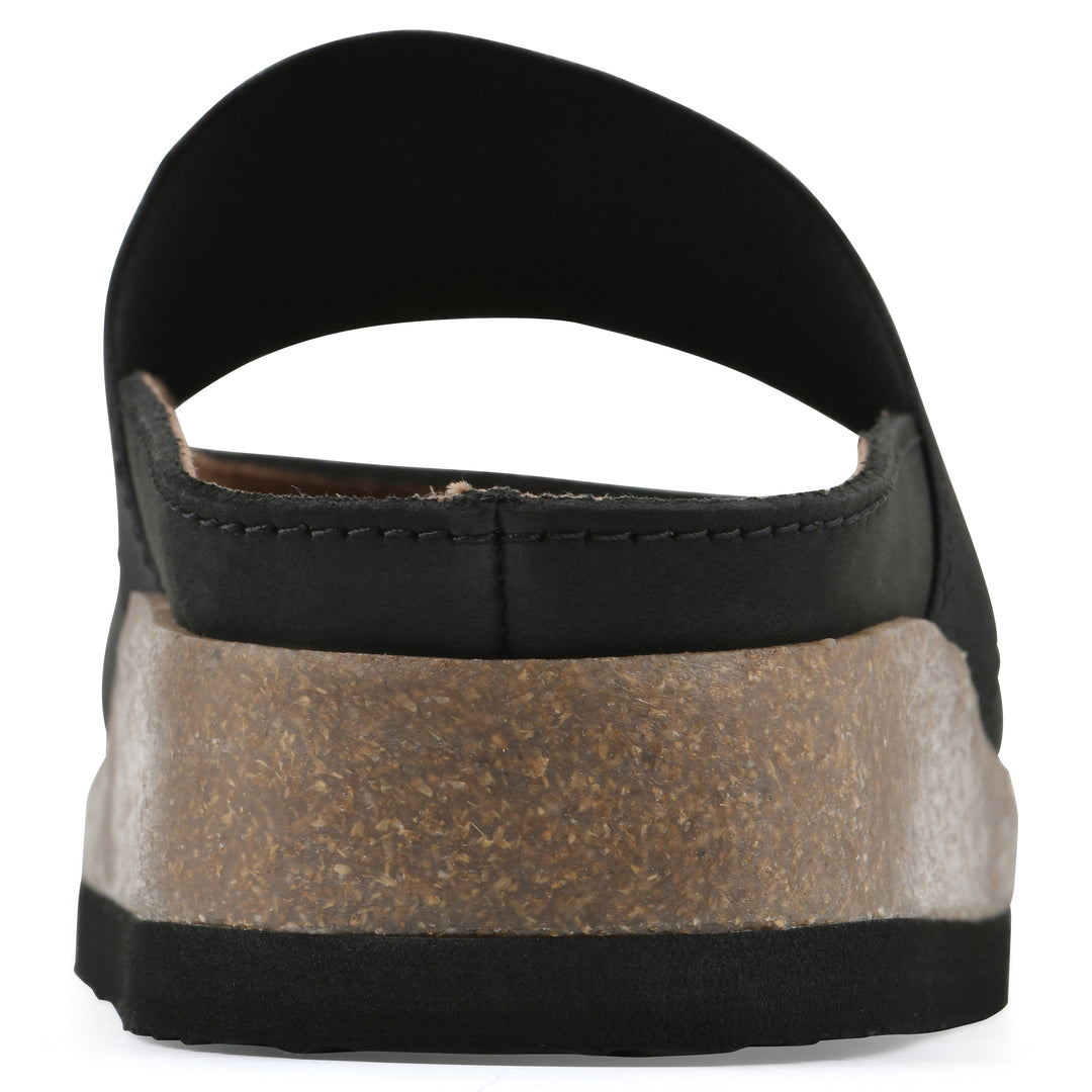 Rear view of a black leather backless clog with Mary Jane style center strap and a brown sole with black bottom