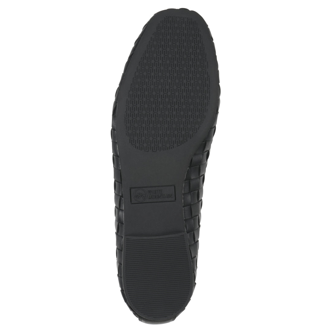 Sole view of a quilted style black flat with low brown sole