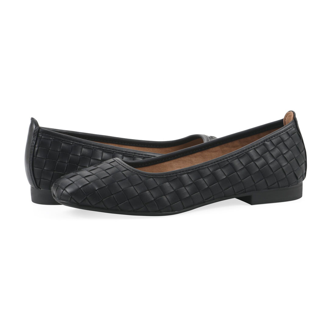 Angle view of a pair of quilted style black flats with low brown sole