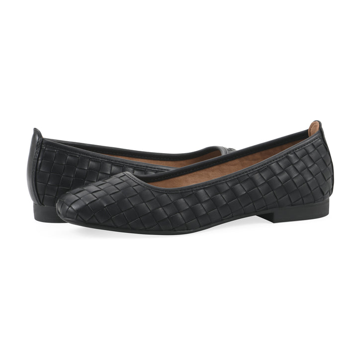 Angle view of a pair of quilted style black flats with low brown sole