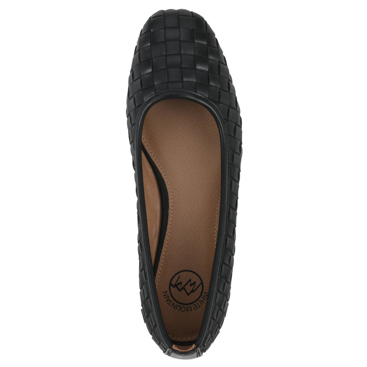 Top view of a quilted style black flat with low brown sole