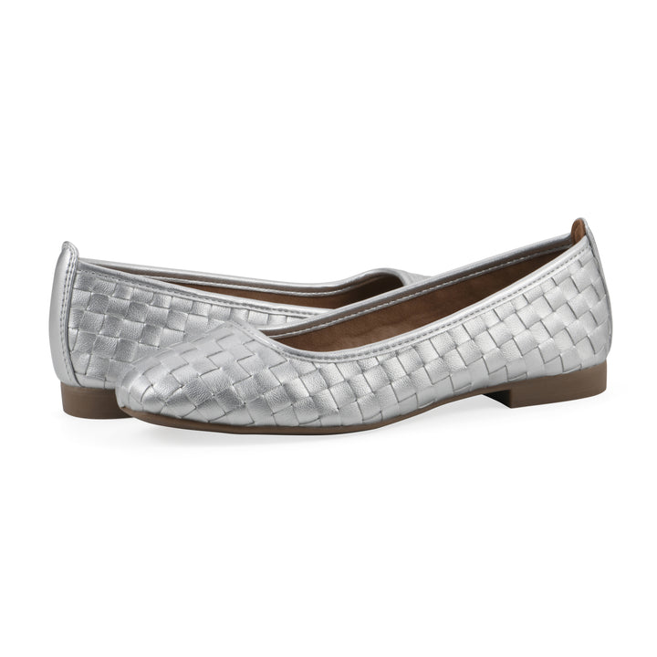 Angle view of a pair of quilted style silver flats with low brown sole
