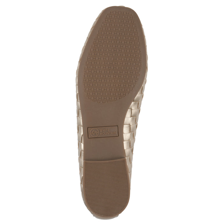 Sole view of a quilted style light gold flat with low brown sole