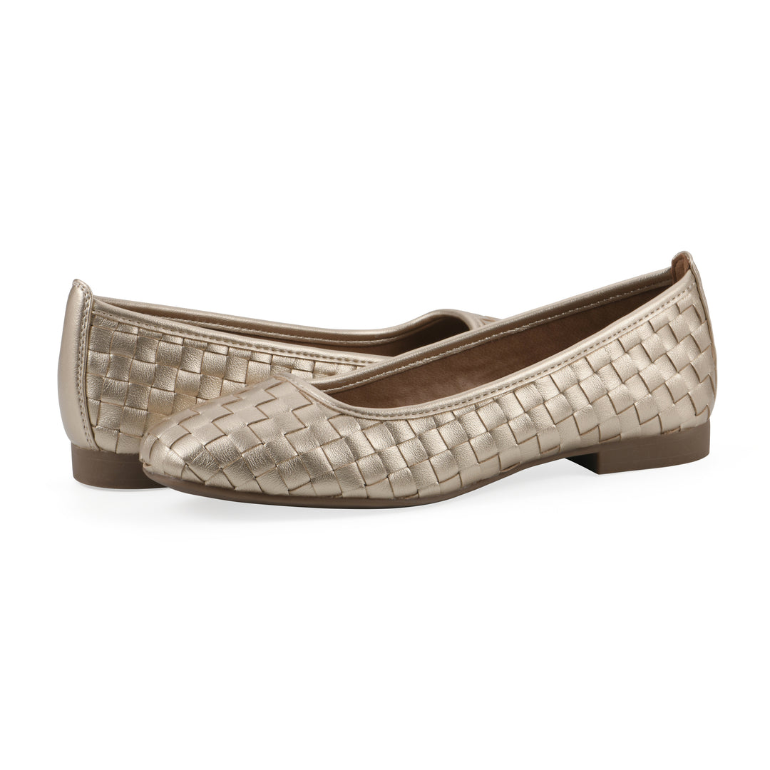 Angle view of a pair of quilted style light gold flats with low brown sole