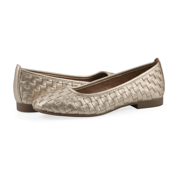 Angle view of a pair of quilted style light gold flats with low brown sole