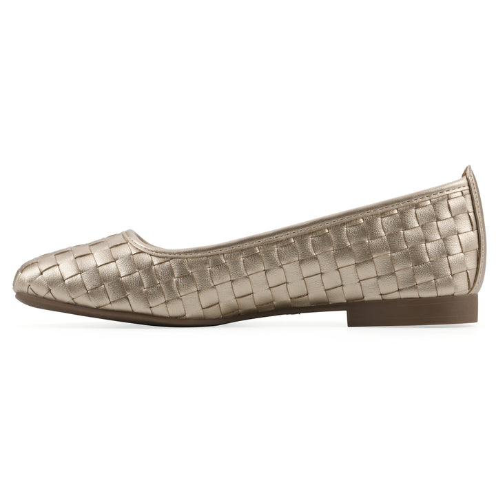 Side view of a quilted style light gold flat with low brown sole