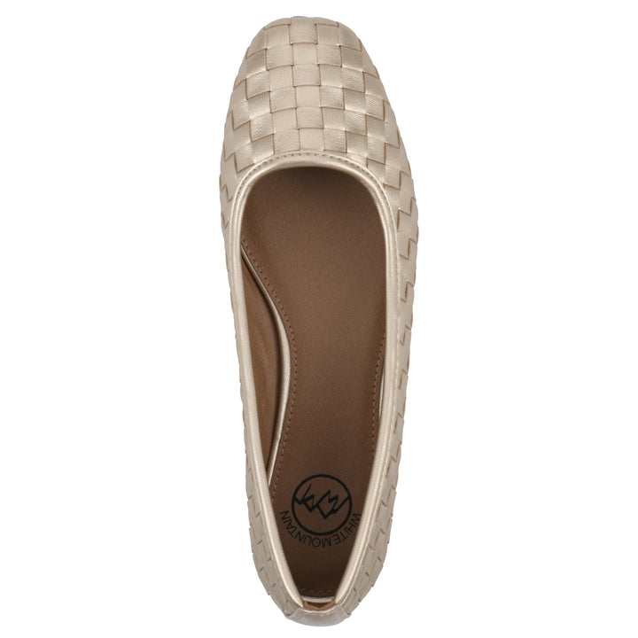 Top view of a quilted style light gold flat with low brown sole