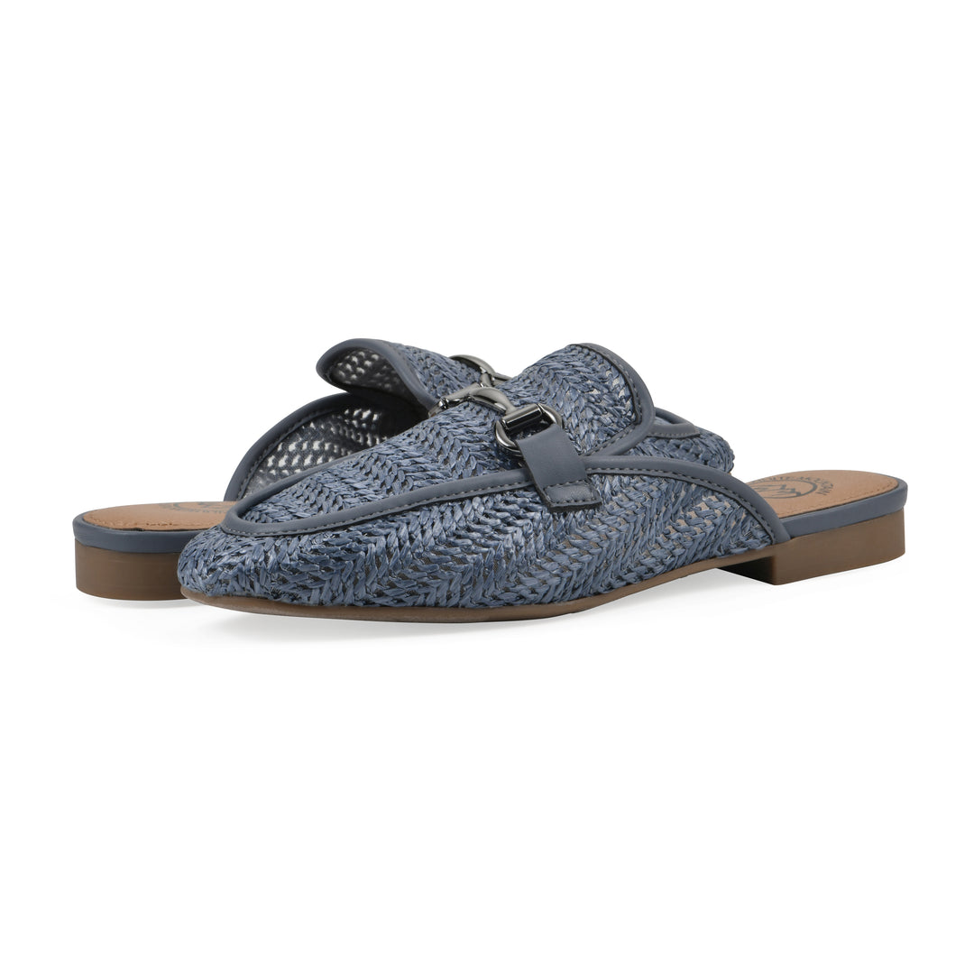 Angle view of a pair of blue raffia mules with horizontal metal embellishment and a black 1/2-inch heel
