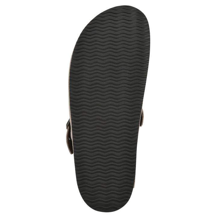 Sole view of a taupe suede backless clog with an adjustable buckle strap with stud and eyelet detailing and a black sole