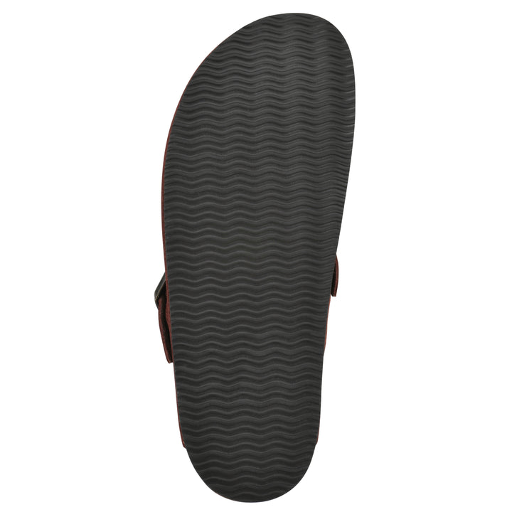 Sole view of a rust suede backless clog with an adjustable buckle strap with stud and eyelet detailing and a black sole