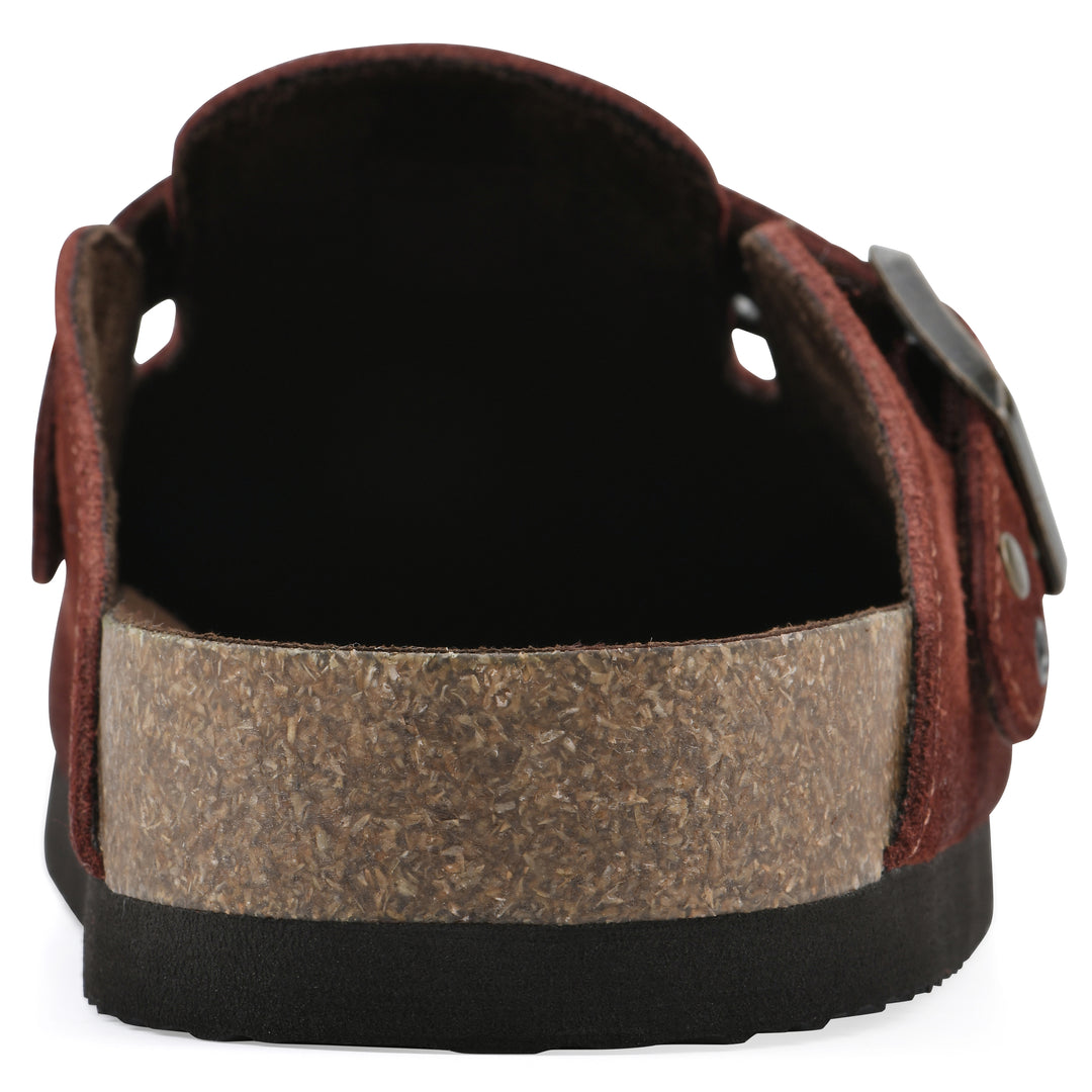 Rear view of a rust suede backless clog with an adjustable buckle strap with stud and eyelet detailing and a black sole
