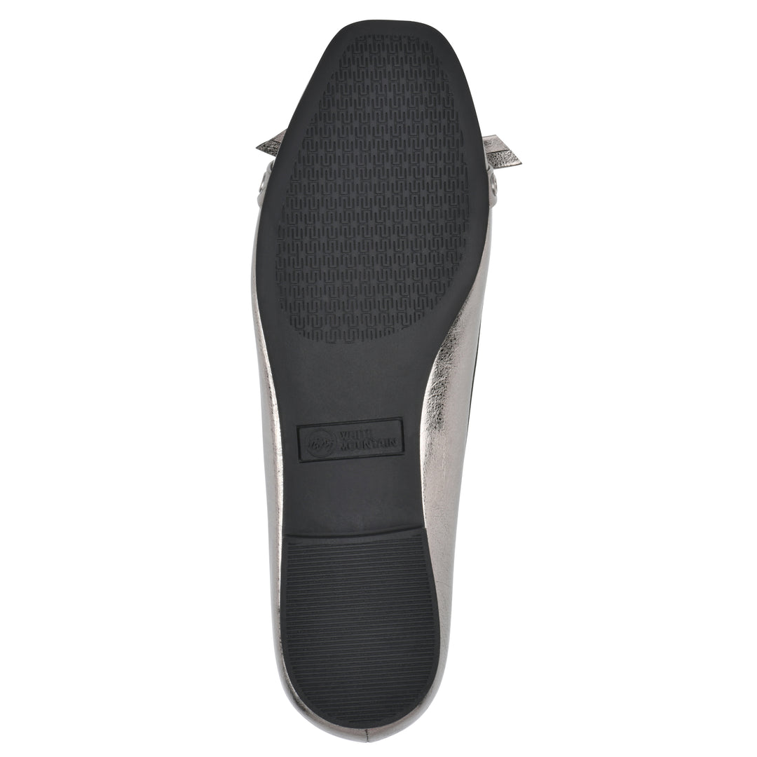 Sole view of a pewter metallic flat with small, centered bow, silver metal grommet lining and a black sole