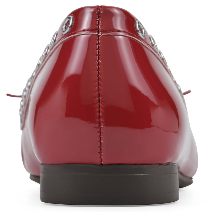 Rear view of a red patent flat with small, centered bow, silver metal grommet lining and a black sole