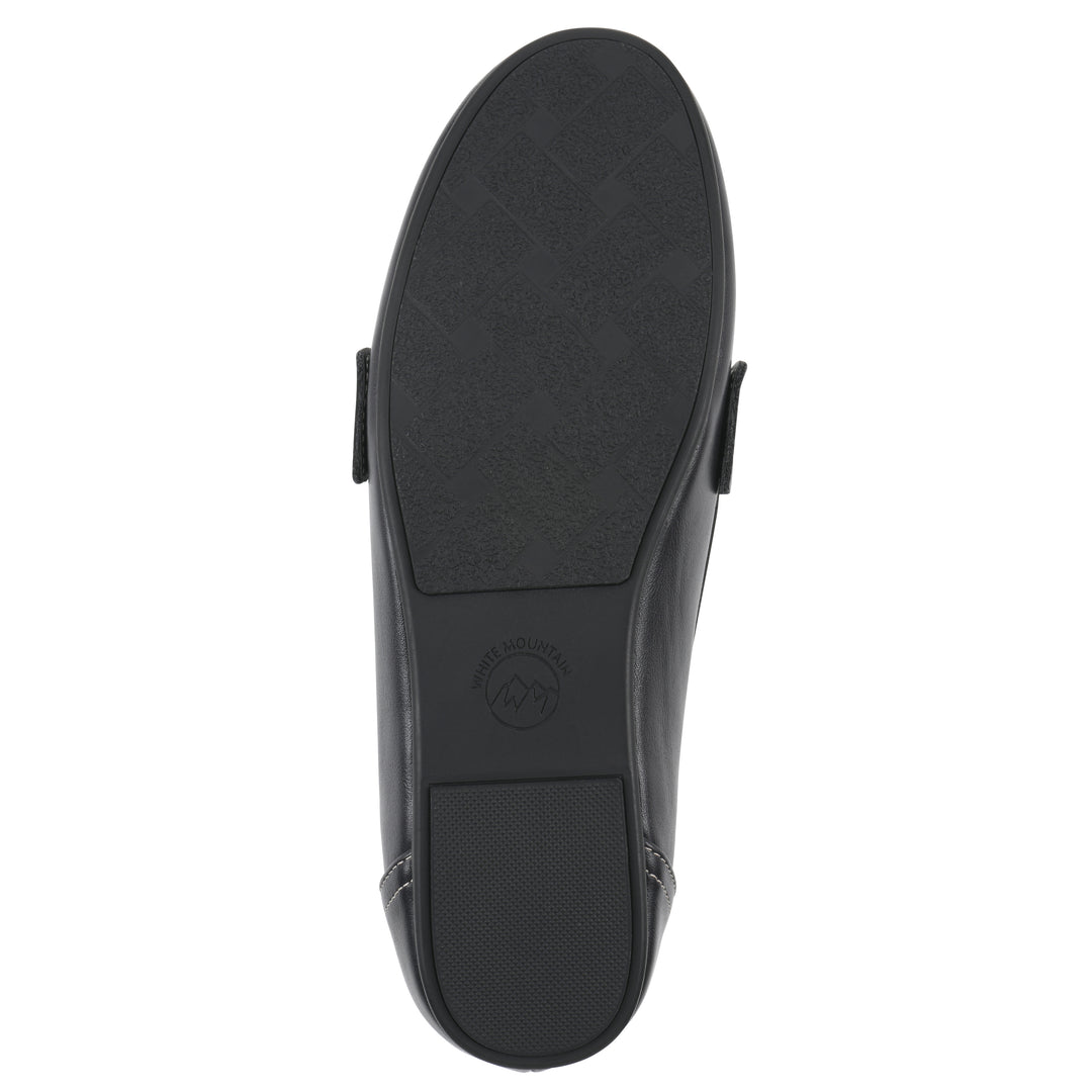 Sole view of a navy loafer shoe with gold buckle 