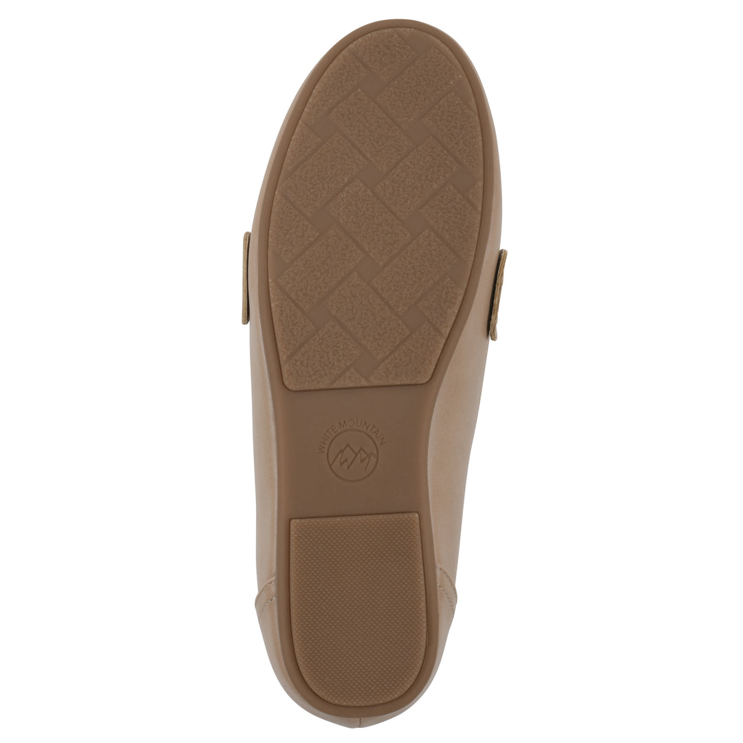 Sole view of a beige loafer with a gold emblem and brown sole