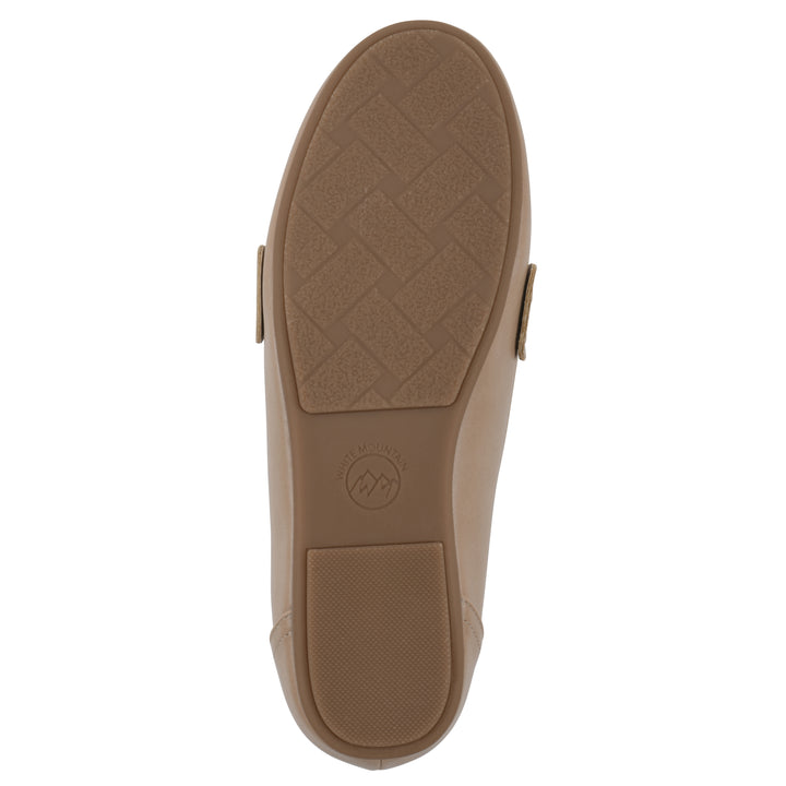 Sole view of a beige loafer with a gold emblem and brown sole