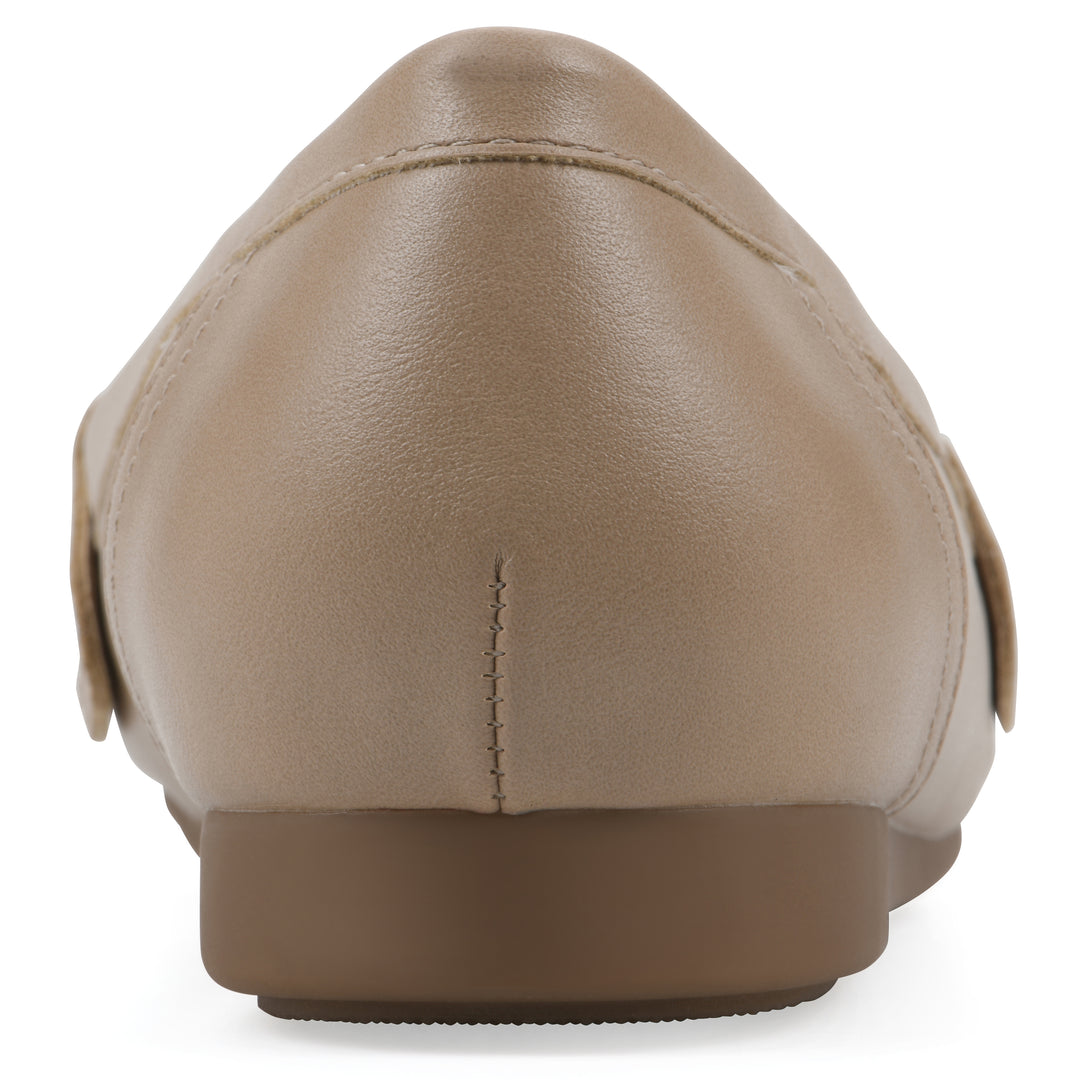 Rear view of a beige loafer with a gold emblem