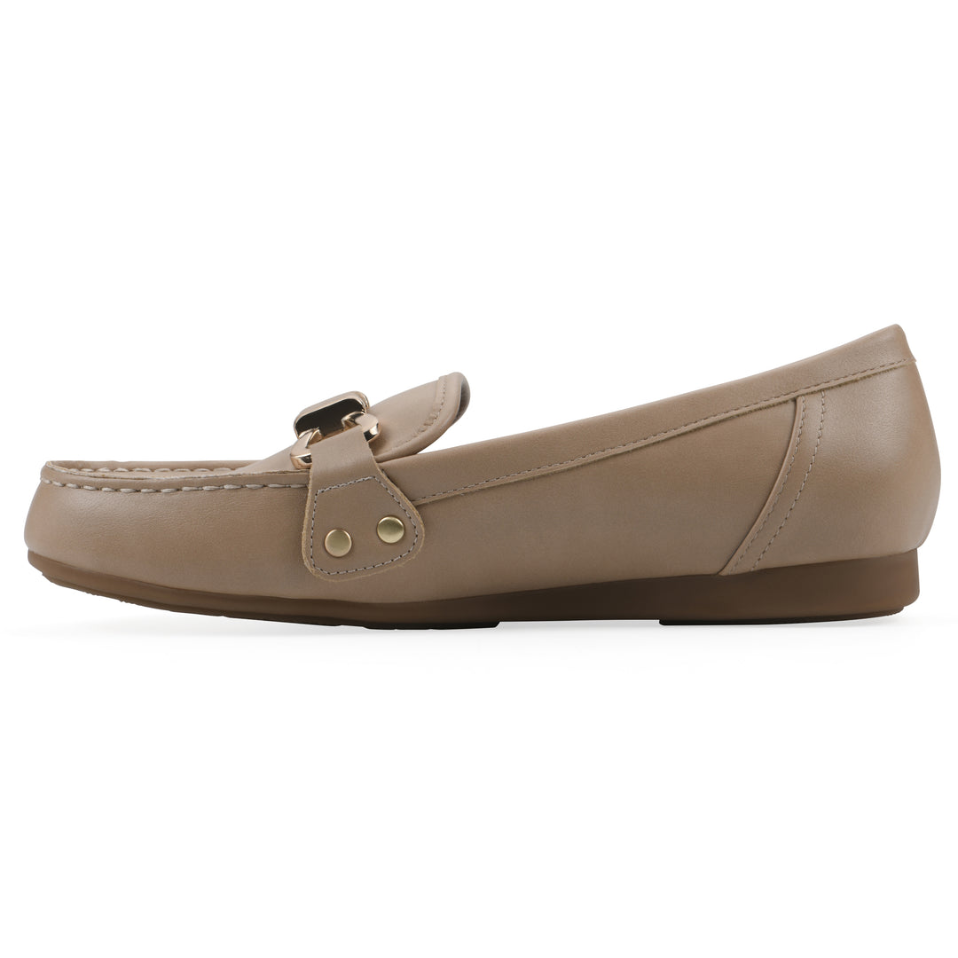 Side view of a beige loafer with a gold emblem