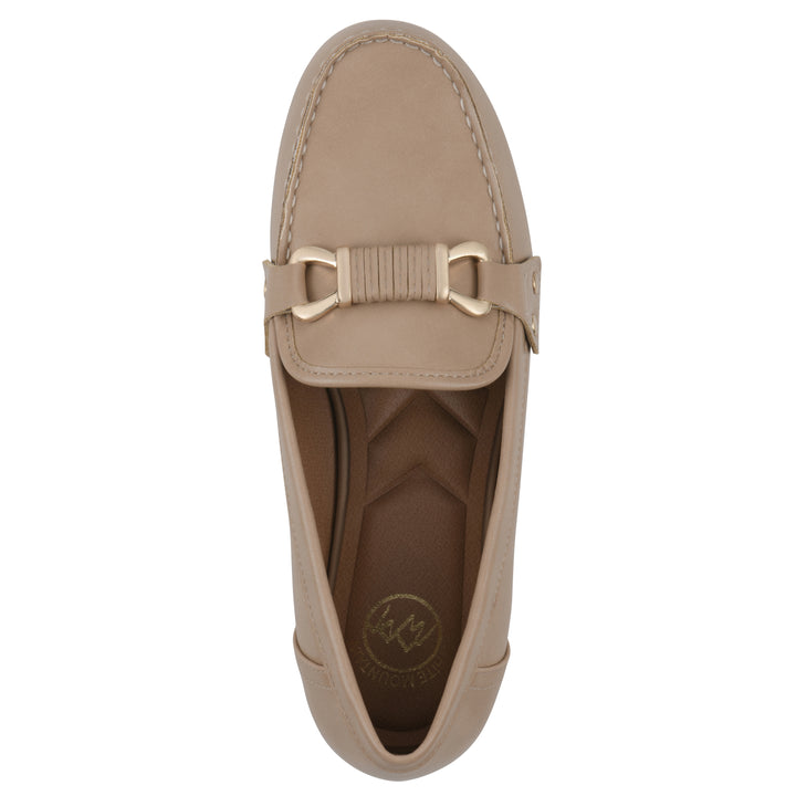 Top view of a beige loafer with a gold emblem
