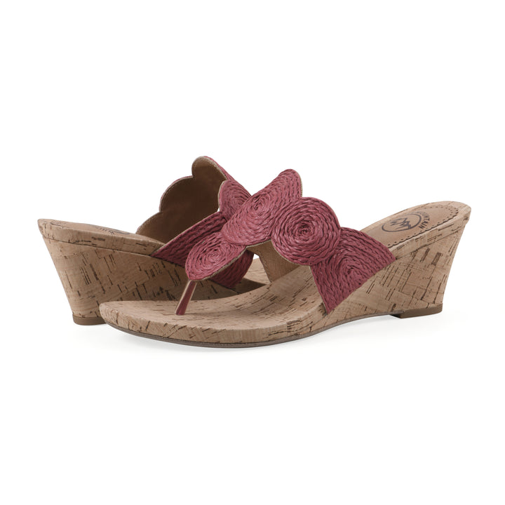 Angle view of a pair of cork print wedge sandal with red raffia thong design