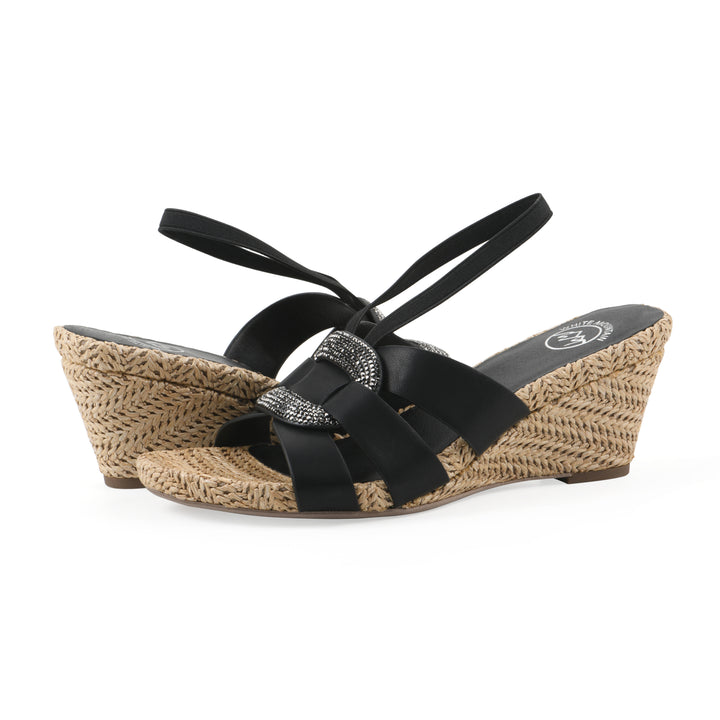 Angle view of a pair of black wedge sandals with elastic heel strap, woven raffia sole and a centered, sequin applique