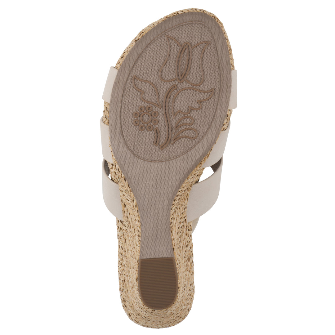 Sole view of a cream wedge sandal with elastic heel strap, woven raffia sole and a centered, sequin applique