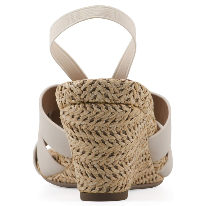 Rear view of a cream wedge sandal with elastic heel strap, woven raffia sole and a centered, sequin applique