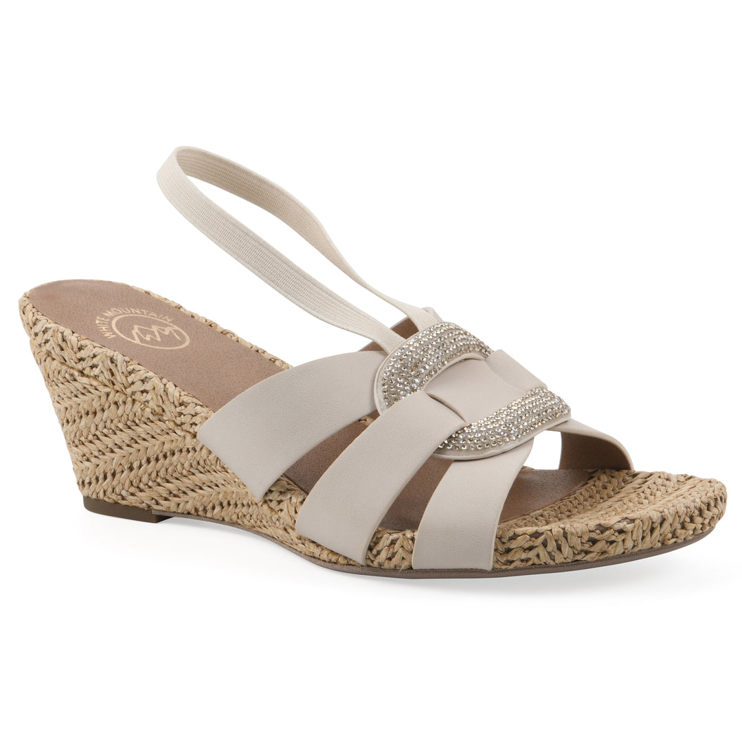 Angle view of a cream wedge sandal with elastic heel strap, woven raffia sole and a centered, sequin applique