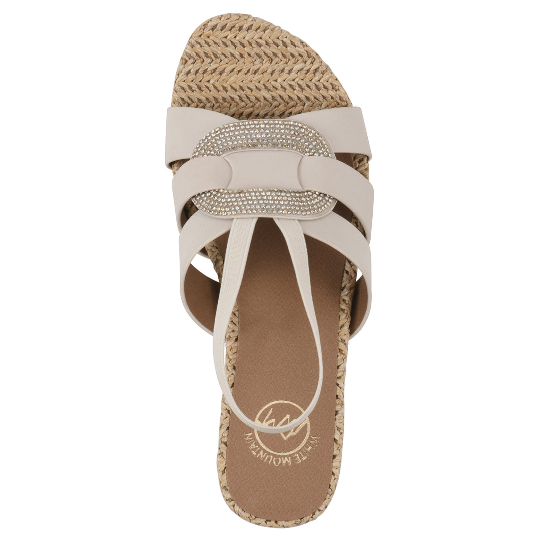 Top view of a cream wedge sandal with elastic heel strap, woven raffia sole and a centered, sequin applique