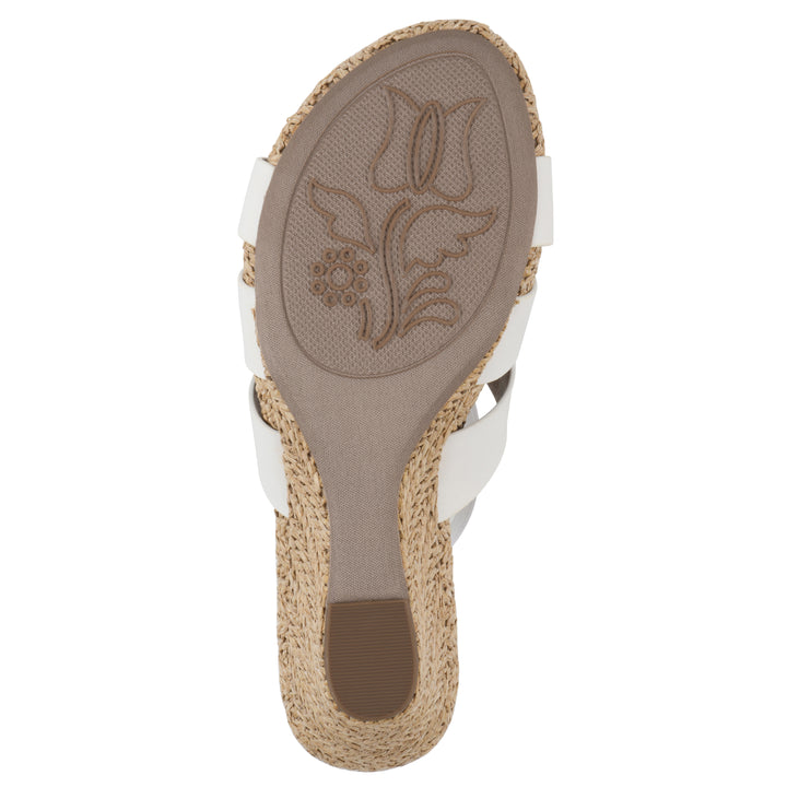 Sole view of a white wedge sandal with elastic heel strap, woven raffia sole and a centered, sequin applique