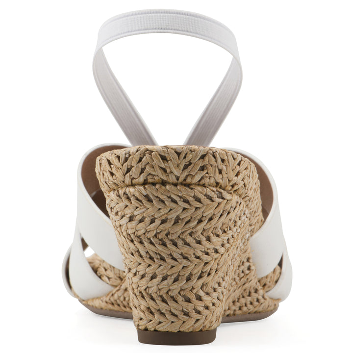 Rear view of a white wedge sandal with elastic heel strap, woven raffia sole and a centered, sequin applique