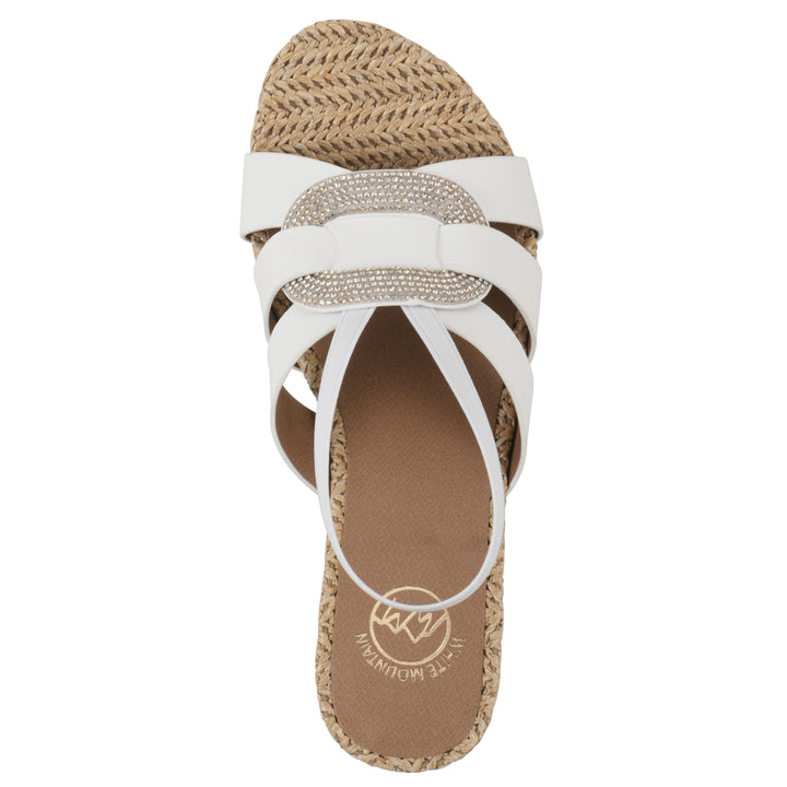 Top view of a white wedge sandal with elastic heel strap, woven raffia sole and a centered, sequin applique