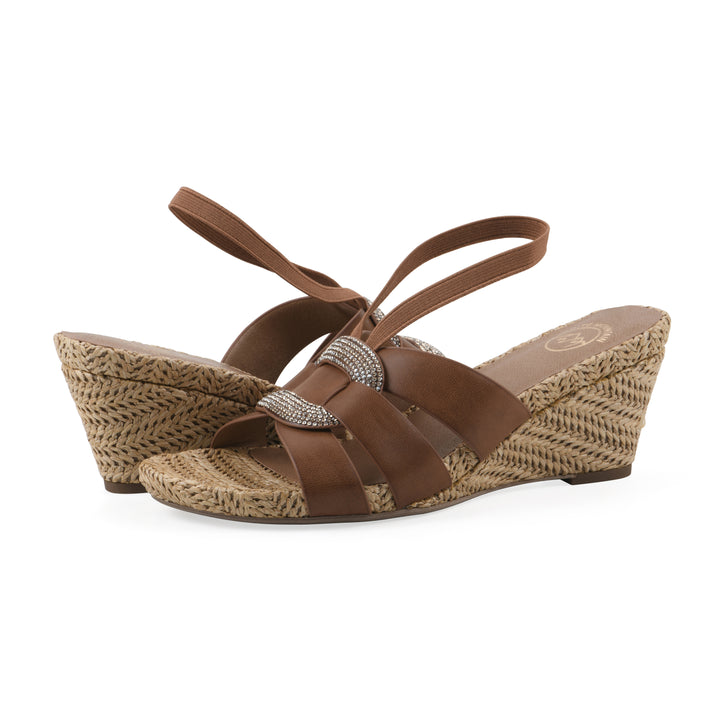 Angle view of a pair of brown wedge sandals with elastic heel strap, woven raffia sole and a centered, sequin applique