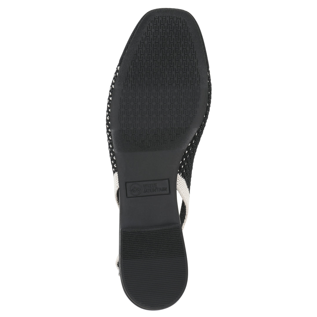 Sole view of a black and white fly-knit slingback with low black heel